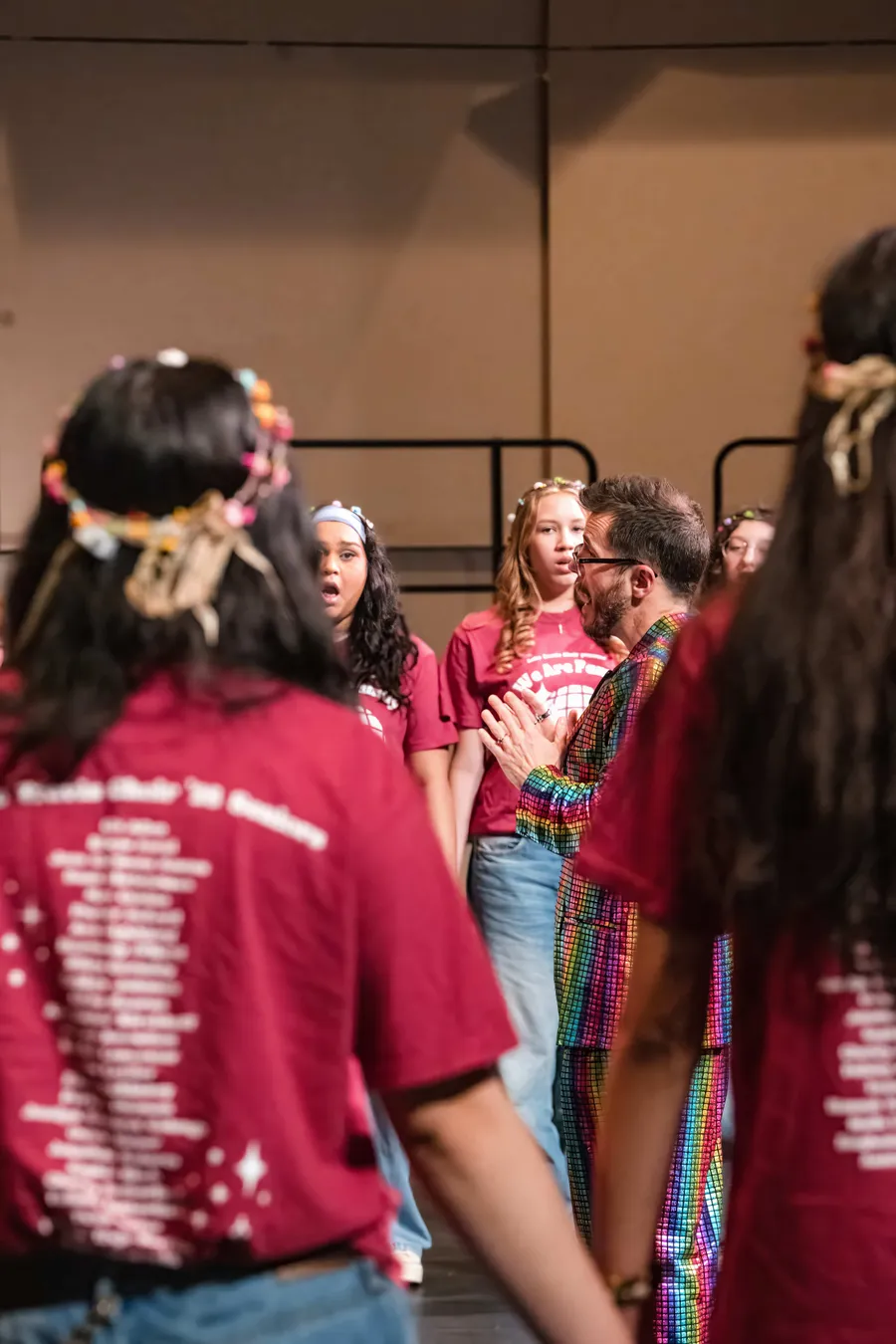 Director joining singers among the flower crowns